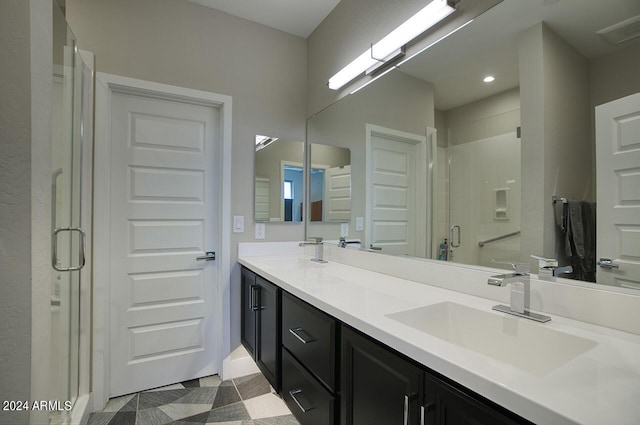 full bathroom with a shower stall, double vanity, visible vents, and a sink