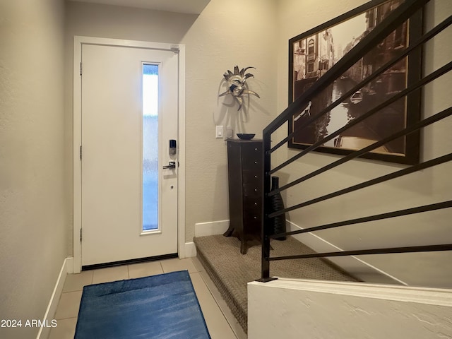 tiled entryway with stairway and baseboards