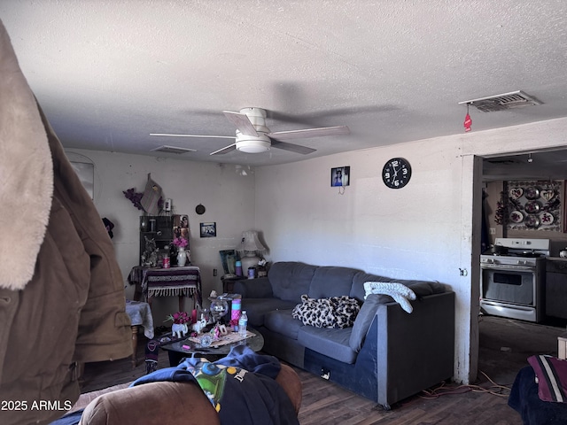 living room featuring dark hardwood / wood-style flooring, a textured ceiling, and ceiling fan