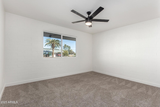 carpeted empty room with brick wall and ceiling fan