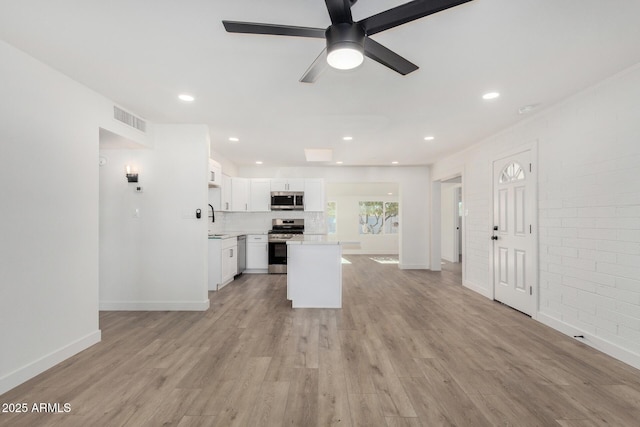 kitchen with ceiling fan, sink, white cabinetry, light hardwood / wood-style floors, and stainless steel appliances