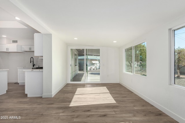 unfurnished room with sink, dark wood-type flooring, and lofted ceiling