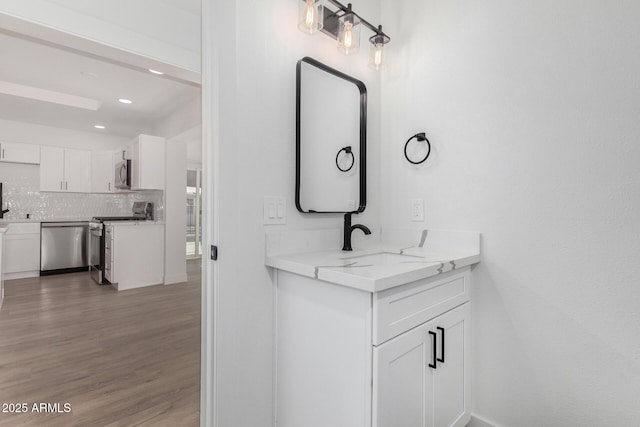 bathroom with sink, backsplash, and wood-type flooring