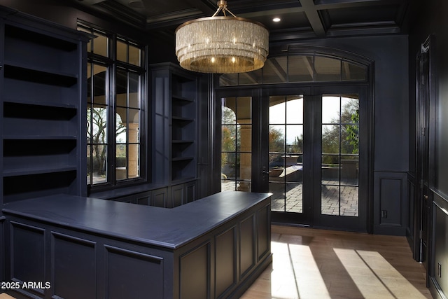 interior space featuring light wood-style floors, beam ceiling, coffered ceiling, and ornamental molding