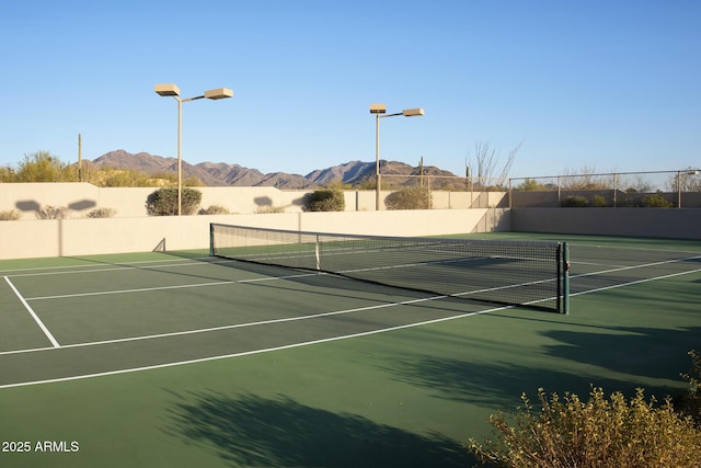 view of sport court with a mountain view, community basketball court, and fence