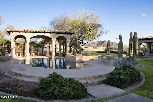 view of property's community with a patio and a mountain view