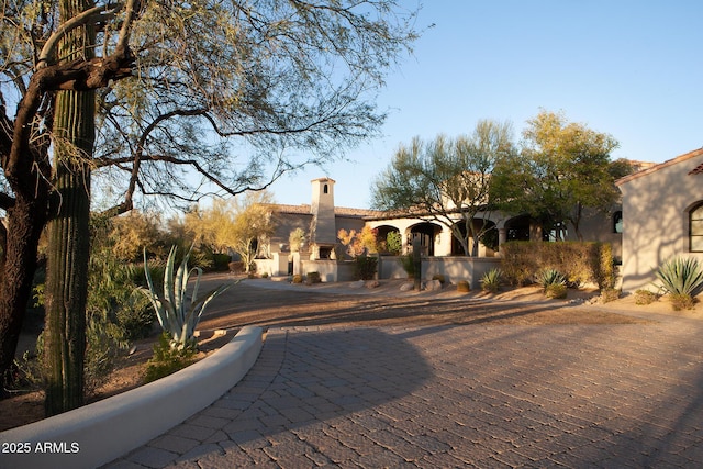 mediterranean / spanish home featuring stucco siding and a chimney