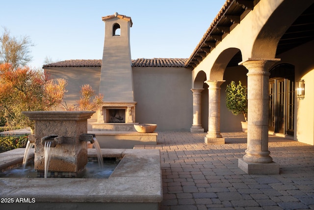 view of patio with exterior fireplace