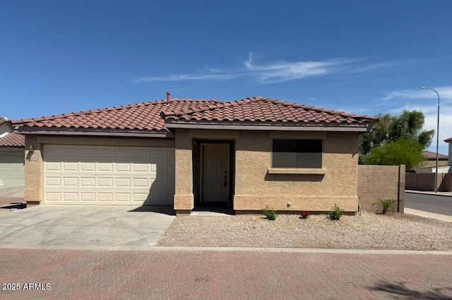 mediterranean / spanish home with fence, an attached garage, stucco siding, concrete driveway, and a tiled roof