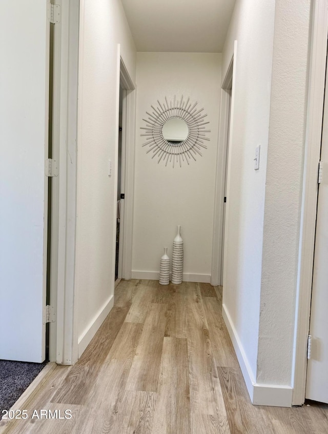 hall with baseboards and wood finished floors