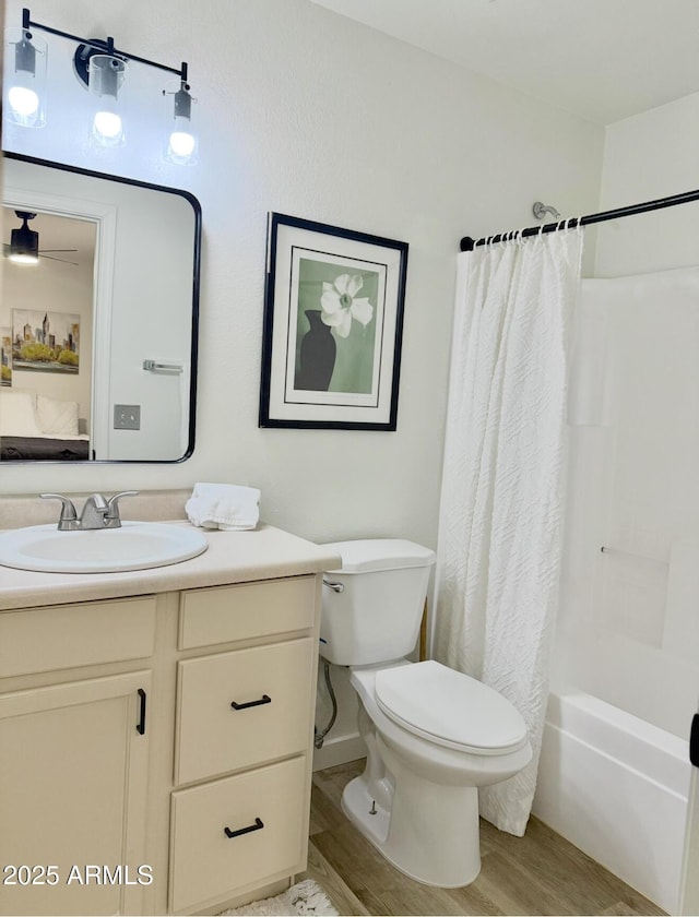 full bath featuring toilet, shower / bathtub combination with curtain, wood finished floors, and vanity