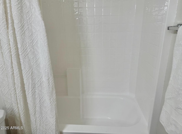 bathroom with shower / bath combo with shower curtain and toilet
