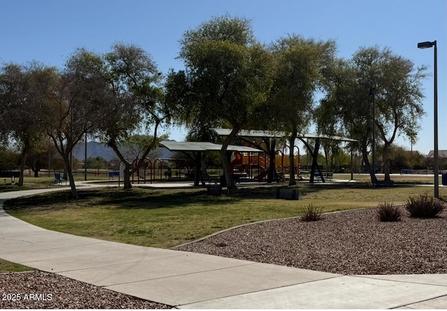 view of property's community featuring a lawn and playground community