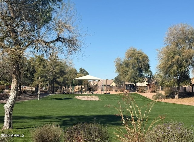 view of community featuring fence and a yard