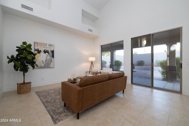 living room with a high ceiling and light tile patterned floors