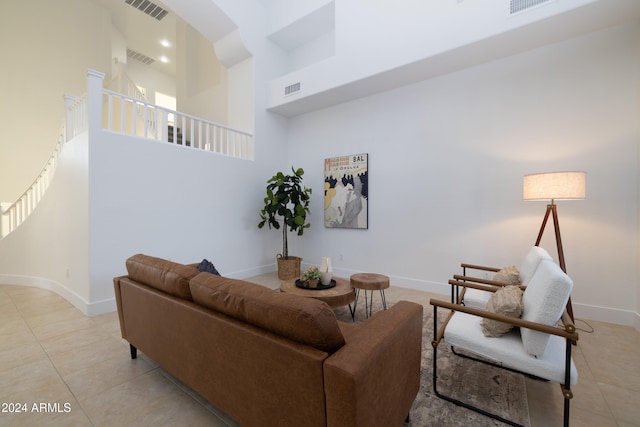 living room featuring a towering ceiling and light tile patterned floors