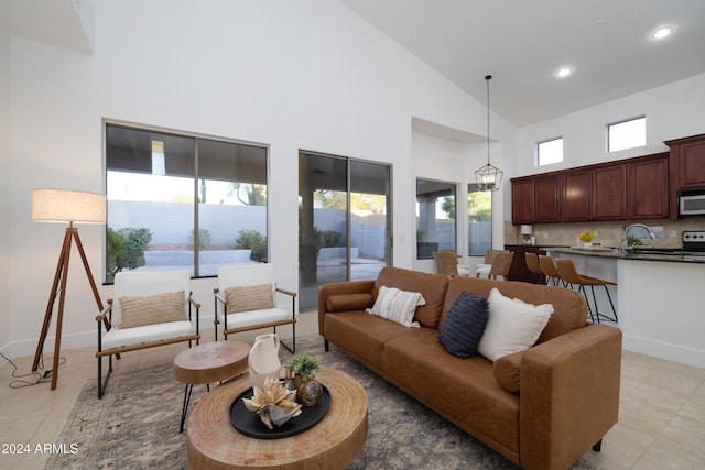 living room with light tile patterned floors, high vaulted ceiling, and a wealth of natural light