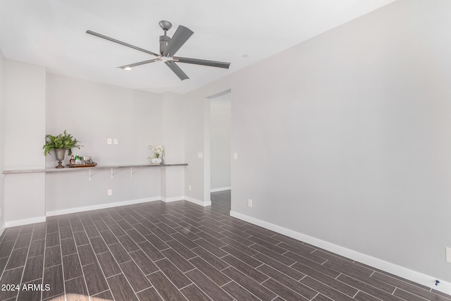 spare room with dark wood-type flooring and ceiling fan