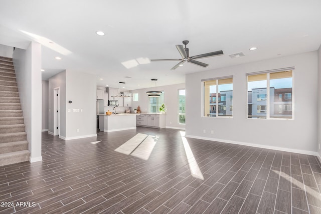 unfurnished living room with ceiling fan and dark hardwood / wood-style floors