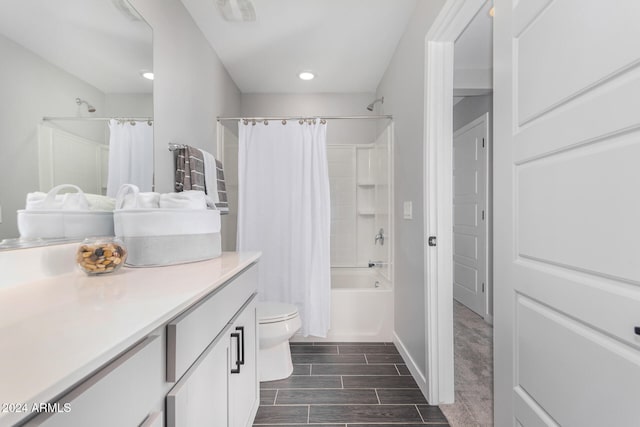 full bathroom with hardwood / wood-style flooring, shower / tub combo with curtain, vanity, and toilet