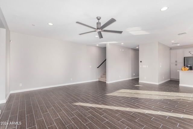 unfurnished living room featuring dark hardwood / wood-style floors and ceiling fan