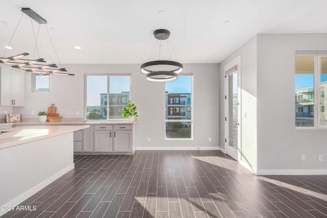 kitchen featuring white cabinets, dark wood-type flooring, and decorative light fixtures