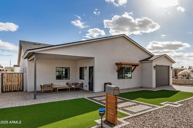 back of property with a garage, a patio, fence, an outdoor living space, and stucco siding