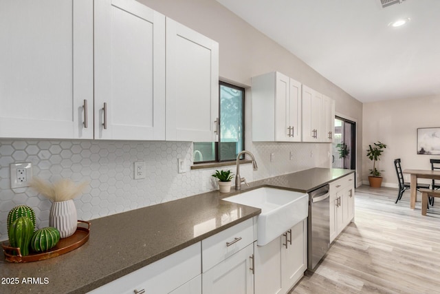 kitchen featuring light wood-type flooring, white cabinetry, dishwasher, and a sink