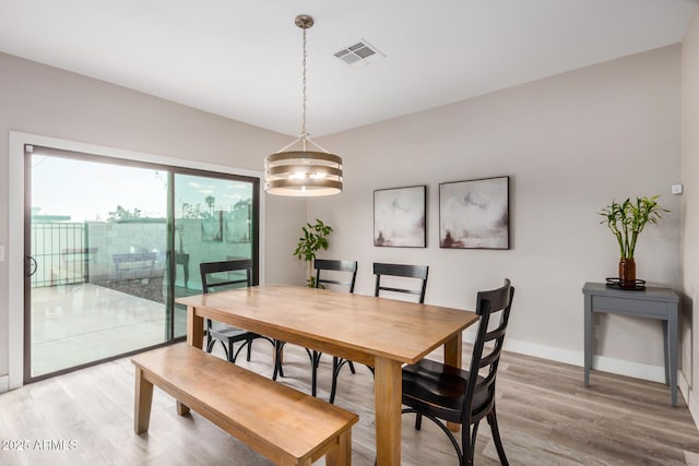 dining room with light wood-style floors, baseboards, and visible vents