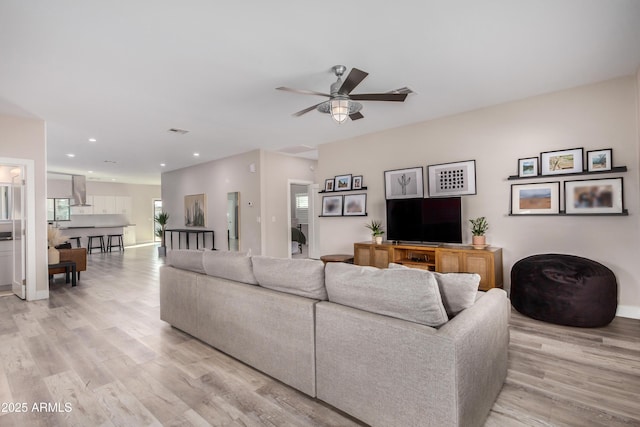 living area featuring ceiling fan, light wood-style flooring, recessed lighting, visible vents, and baseboards