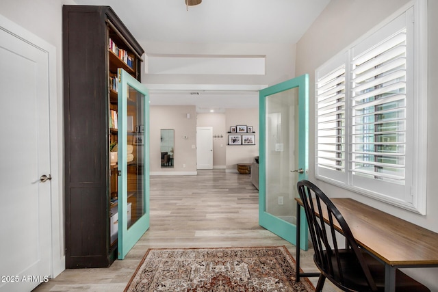 interior space with french doors, baseboards, and light wood finished floors