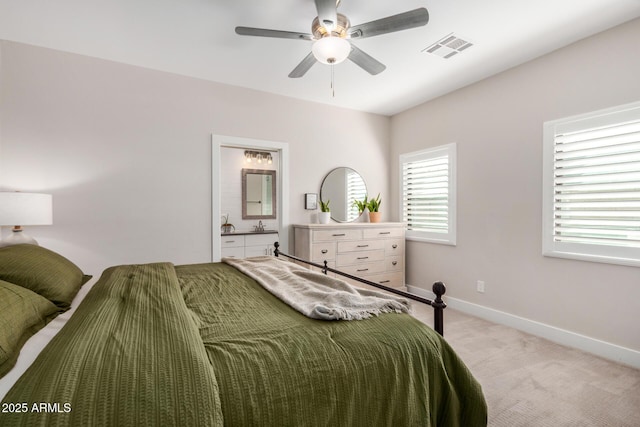 bedroom featuring visible vents, ensuite bathroom, a ceiling fan, light carpet, and baseboards