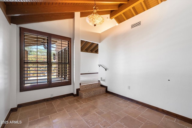 spare room with baseboards, visible vents, lofted ceiling with beams, stone tile flooring, and wood ceiling