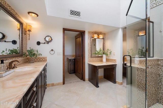 bathroom featuring tile patterned floors, visible vents, a stall shower, baseboards, and vanity