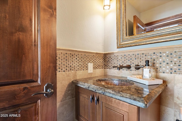 bathroom with a wainscoted wall, tile walls, and vanity