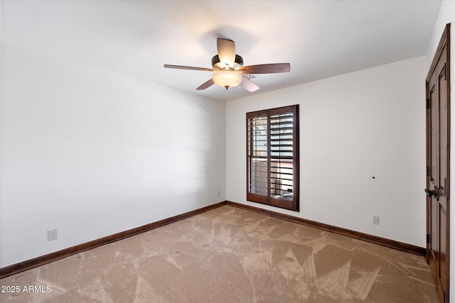 carpeted empty room featuring ceiling fan and baseboards