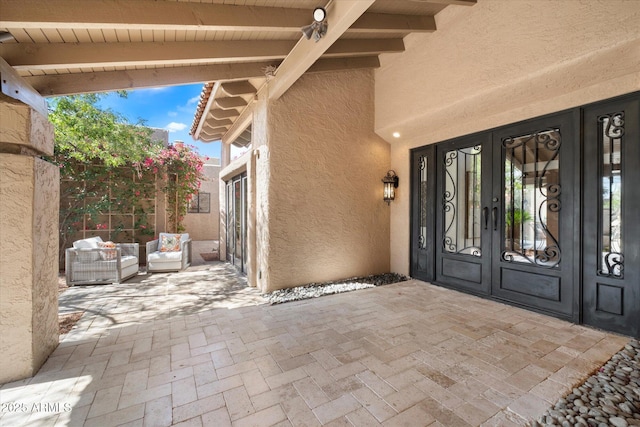 view of exterior entry with a patio area, french doors, and stucco siding