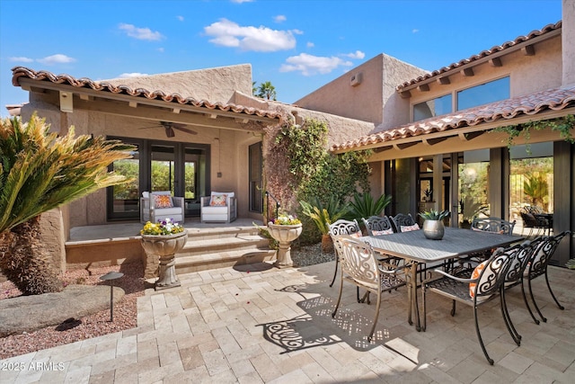 view of patio / terrace featuring ceiling fan, french doors, and outdoor dining space