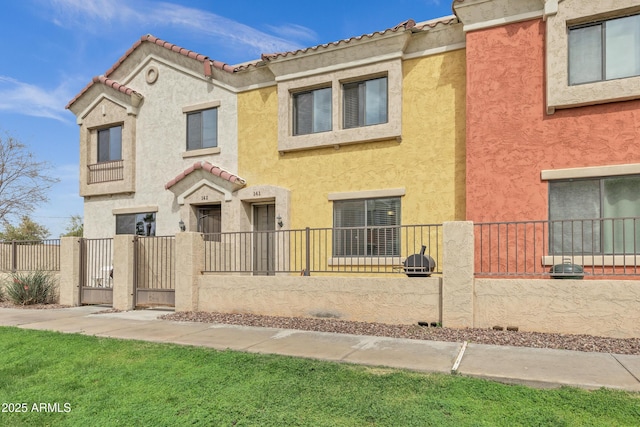 view of front of property featuring a fenced front yard, stucco siding, and a gate