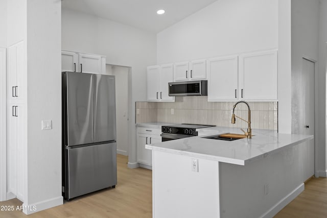 1881 E Kerby Farms Rd, Chandler, AZ 85249 - kitchen featuring appliances with stainless steel finishes, a peninsula, white cabinets, and light stone counters