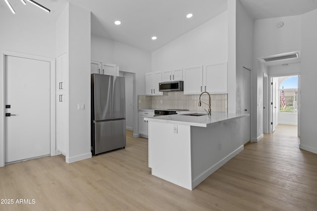 1881 E Kerby Farms Rd, Chandler, AZ 85249 - kitchen featuring appliances with stainless steel finishes, high vaulted ceiling, white cabinetry, a peninsula, and light countertops