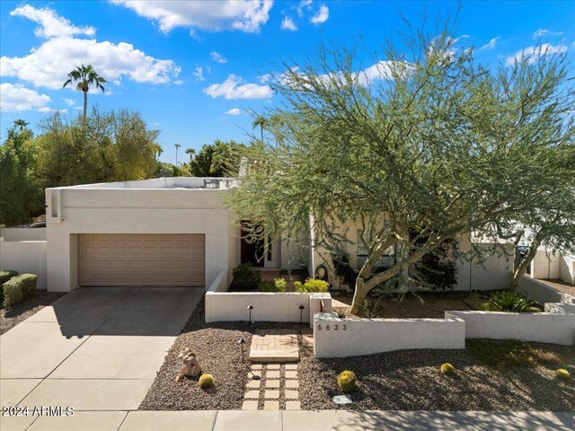 pueblo-style house featuring a garage