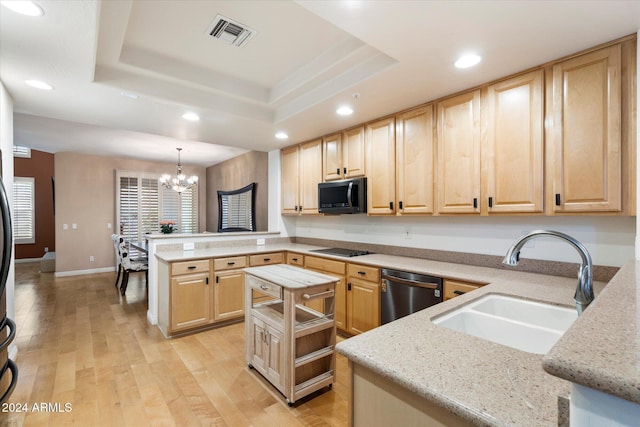 kitchen featuring kitchen peninsula, sink, dishwashing machine, hanging light fixtures, and a tray ceiling