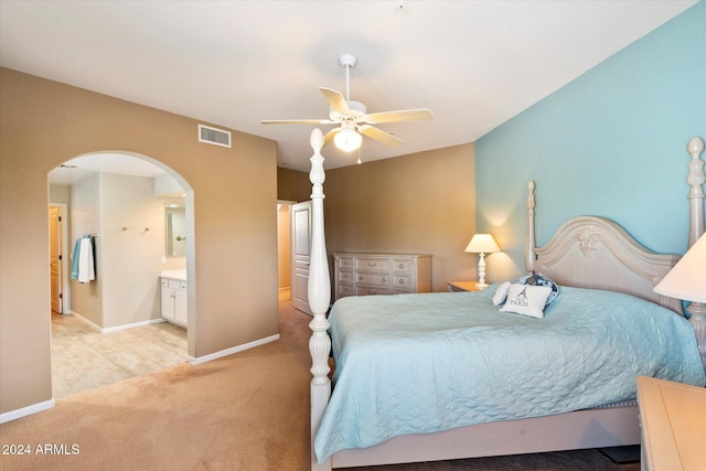 carpeted bedroom with ensuite bathroom and ceiling fan