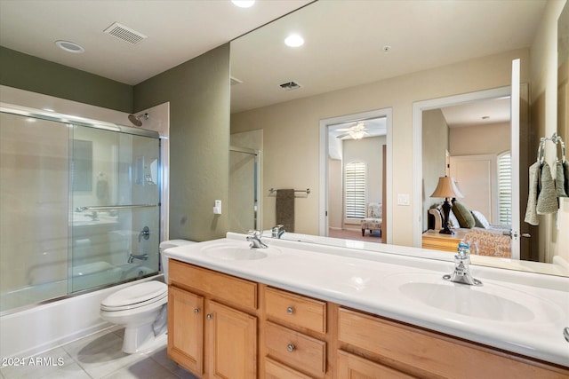 full bathroom with toilet, tile patterned floors, vanity, and bath / shower combo with glass door