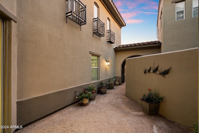 property exterior at dusk with a patio area