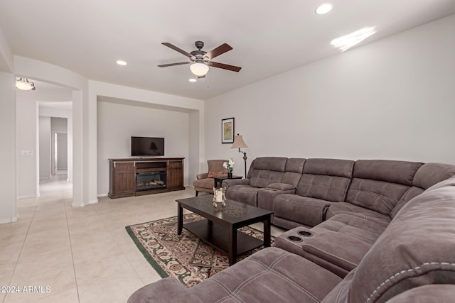 living room featuring baseboards, a glass covered fireplace, ceiling fan, light tile patterned flooring, and recessed lighting