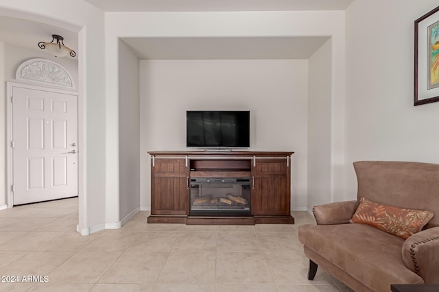 sitting room with light tile patterned floors, baseboards, and a glass covered fireplace