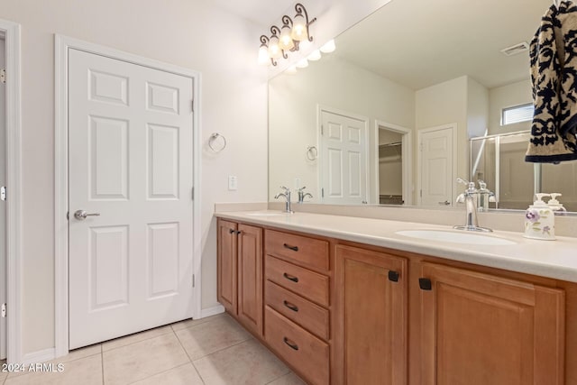 bathroom with double vanity, visible vents, a sink, a shower stall, and tile patterned floors