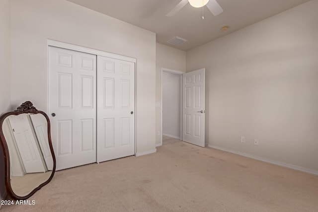 unfurnished bedroom with light carpet, baseboards, visible vents, a ceiling fan, and a closet